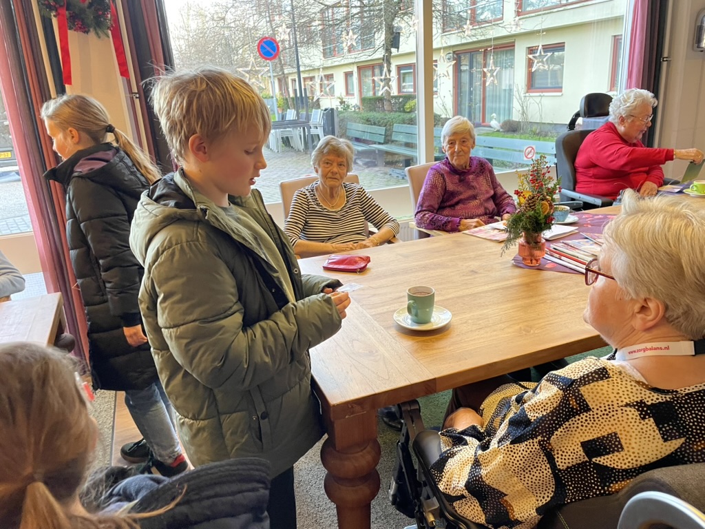 Kinderen drinken samen koffie met ouderen uit de buurt